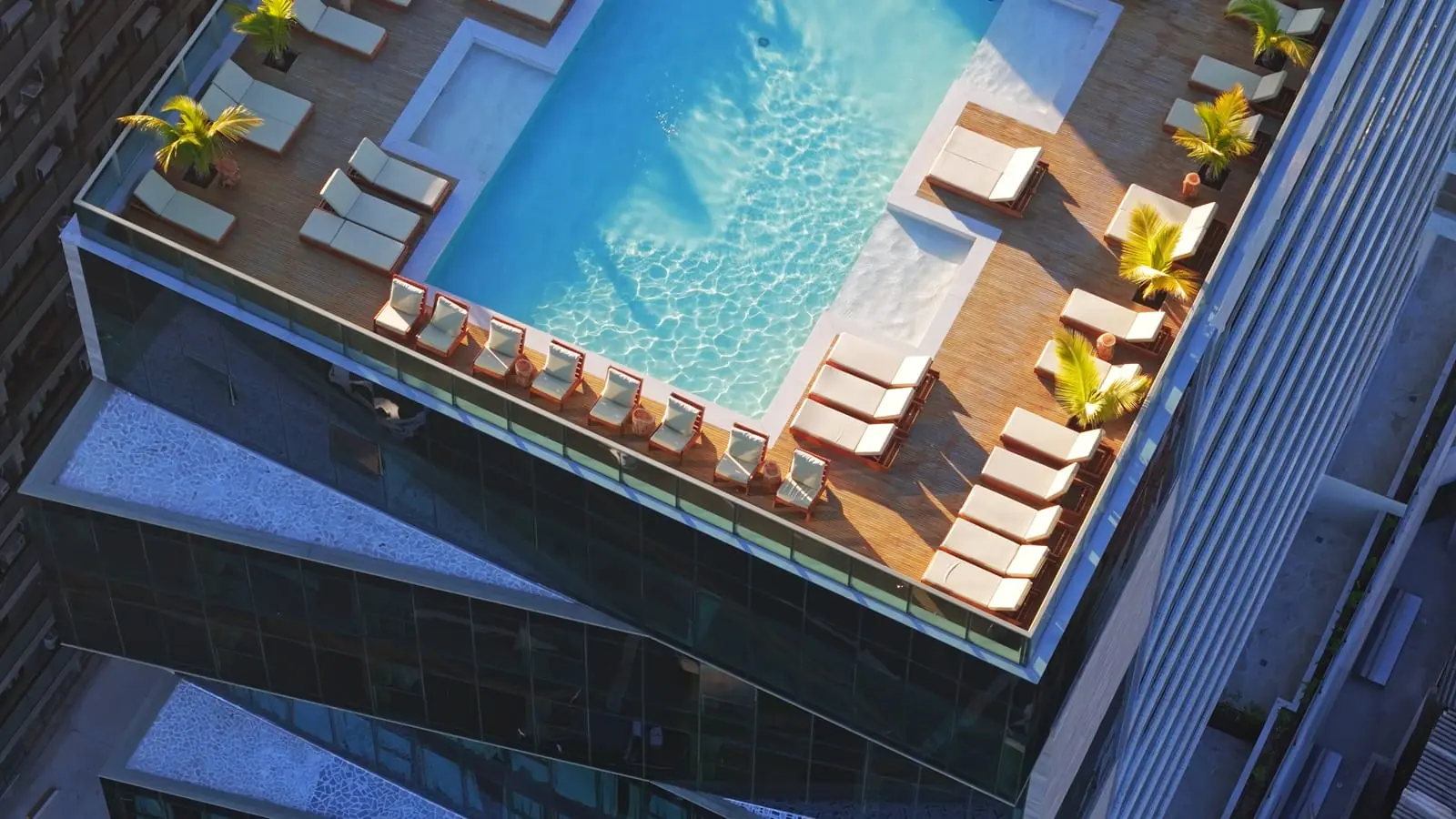 Espreguiçadeiras à beira da piscina do Sais Beach Living, com vista para a Pajuçara